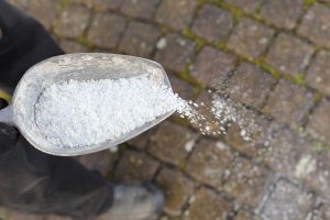 Salt being scooped onto driveway
